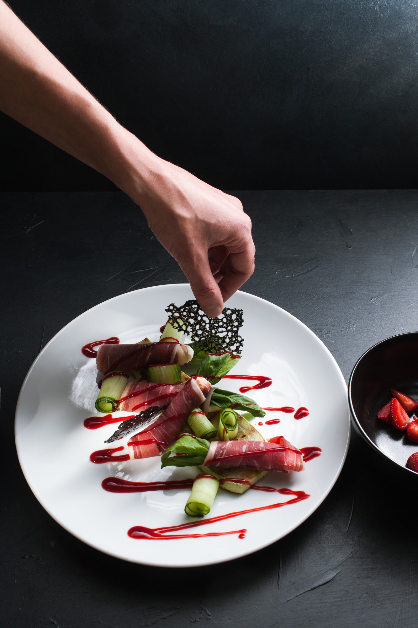 Chef preparing plated dish with bold plating
